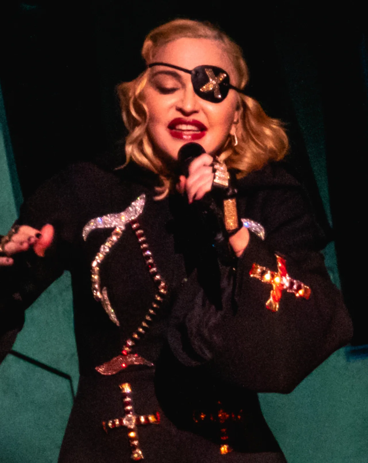 Madonna en concert, micro à la main, tournée Madame X